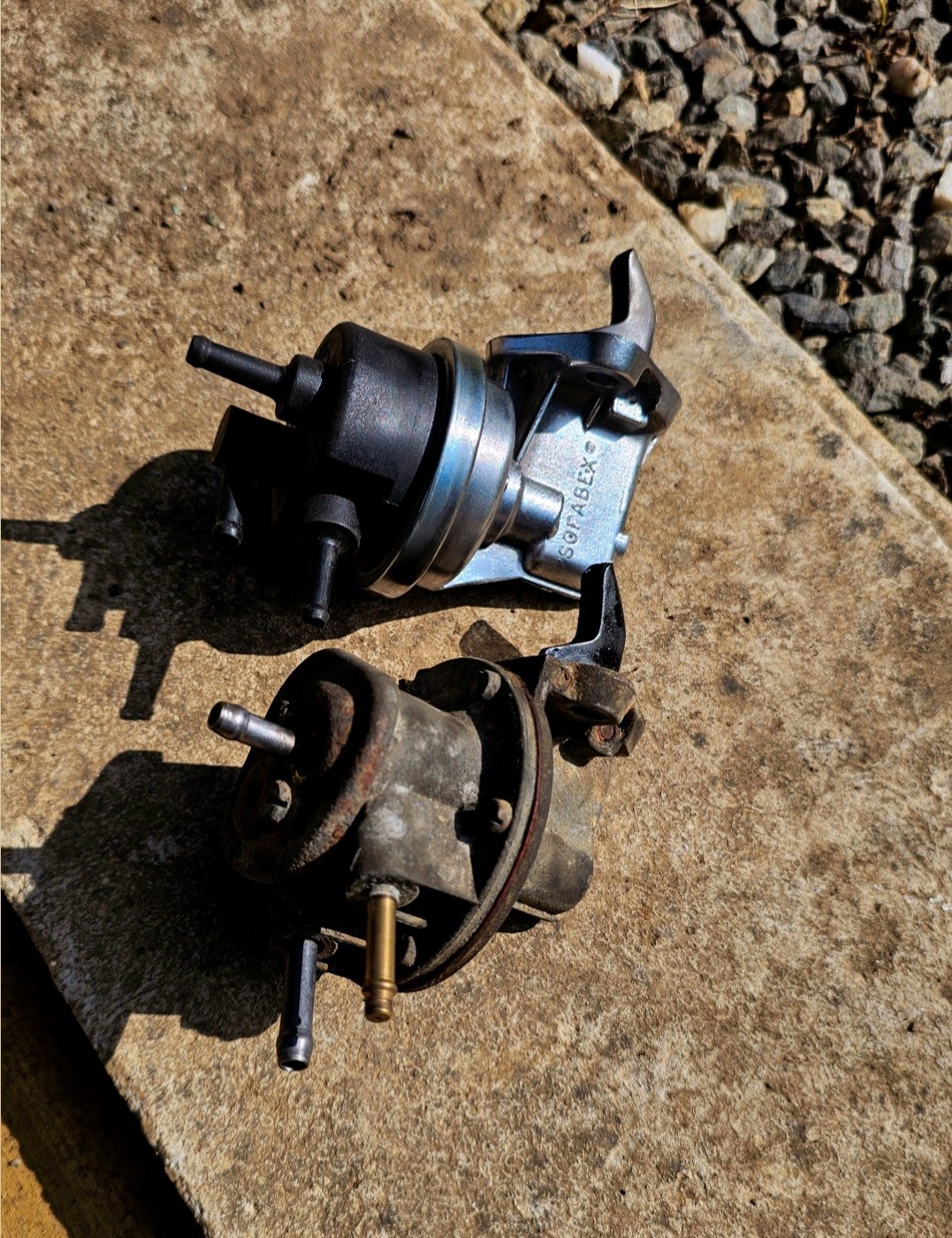 Pompe mécanique ancienne comparée à sa pièce de remplacement